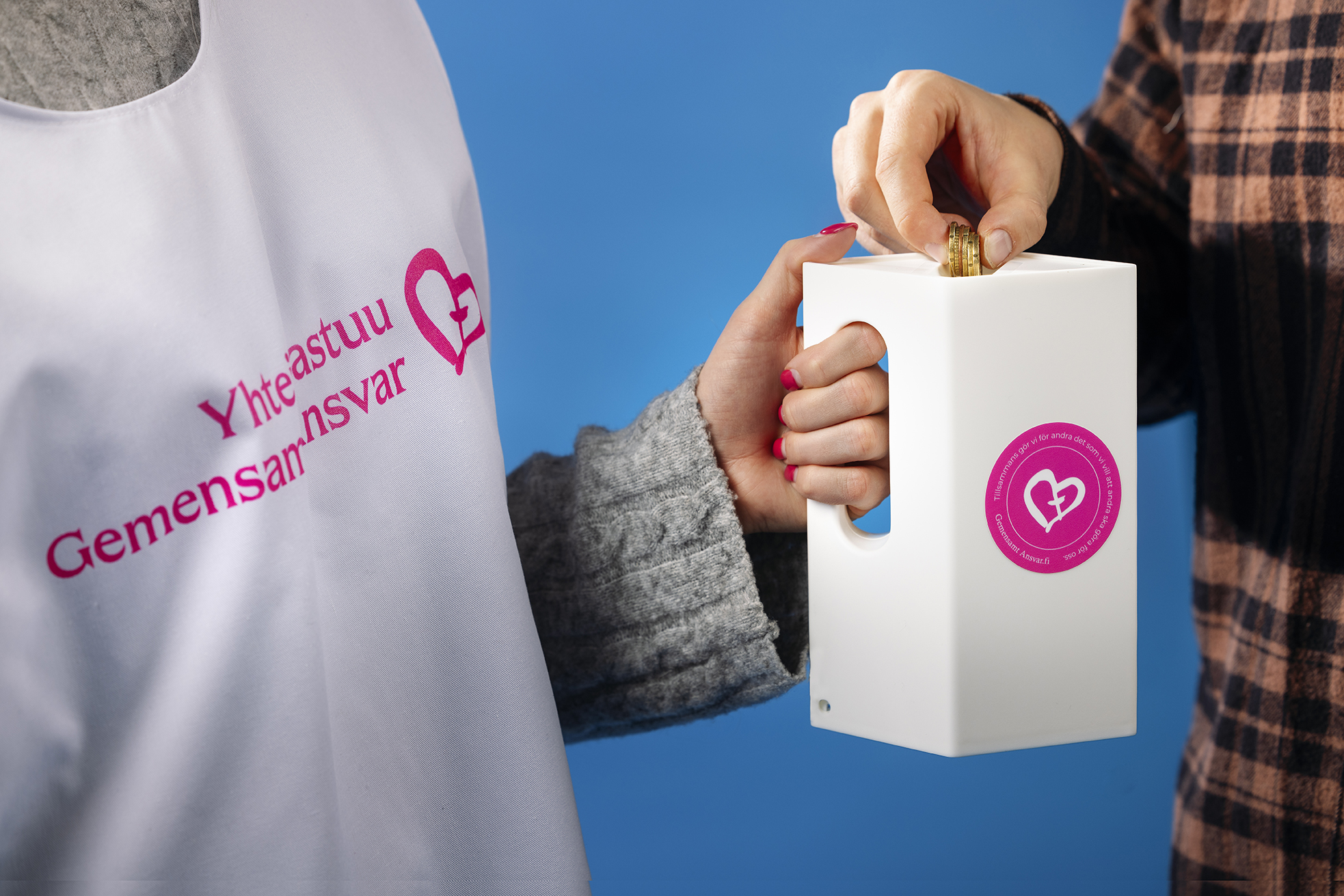 Osallistuja laittaa rahaa kerääjän YV-lippaaseen.