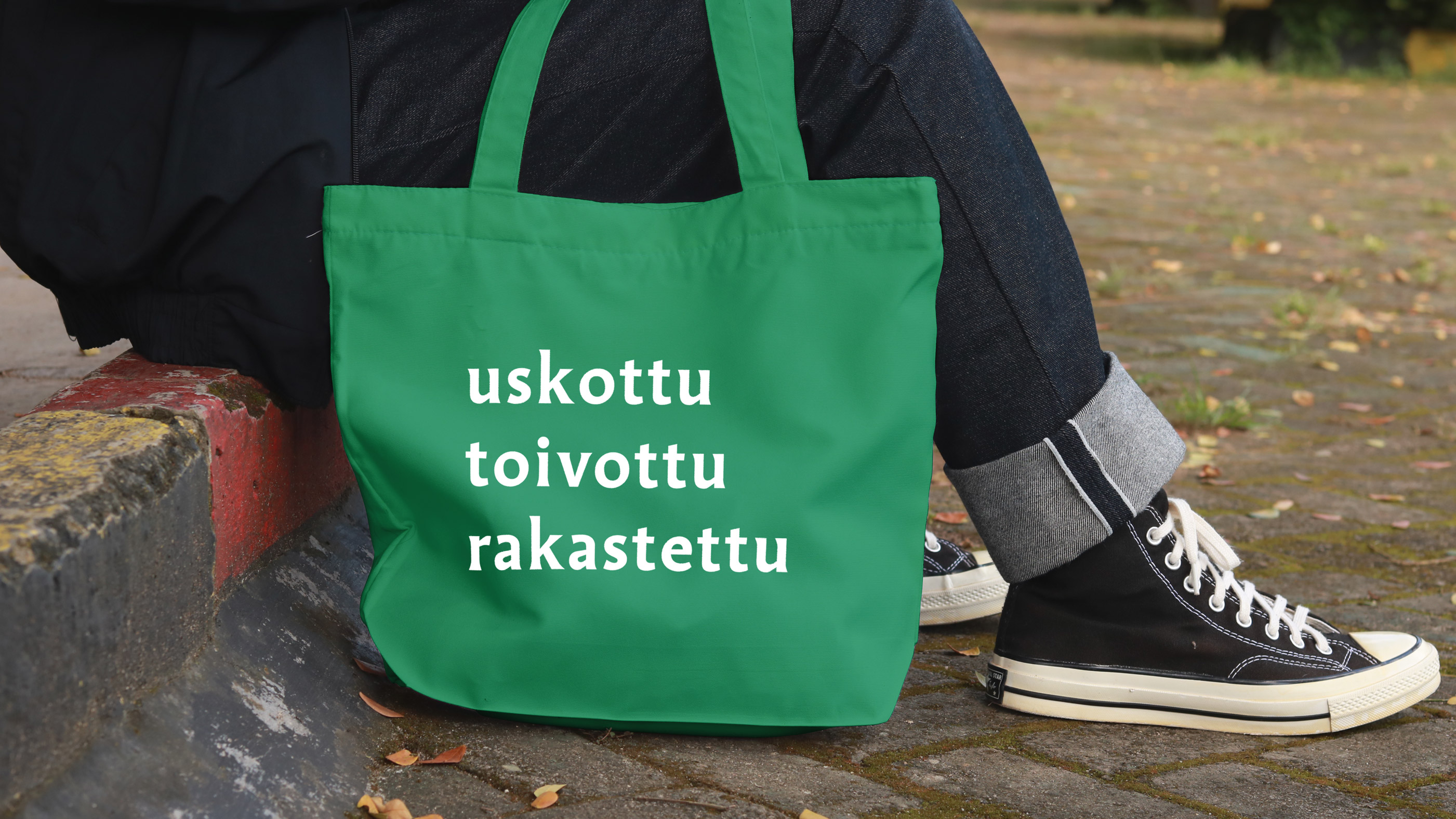 Vihreä kangaskassi, jossa on valkoiset sanat 